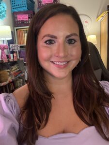 smiling woman brown hair purple dress